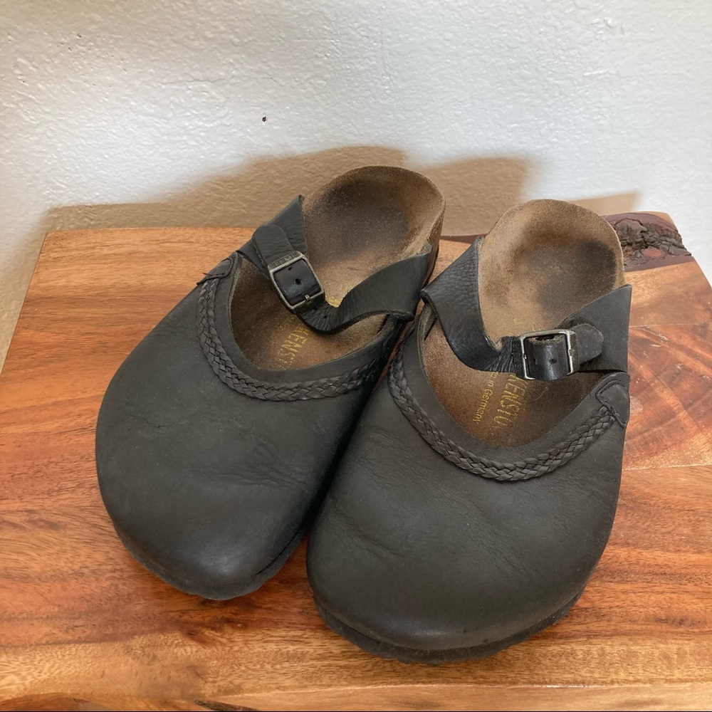 Black Birkenstock clogs with buckle strap